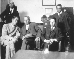 Photograph of Leopold and Loeb with their defense attorney, Clarence Darrow and two unidentified men